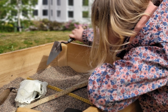 jente som graver etter gjennstander i arkeologi inspirert gravekasse 