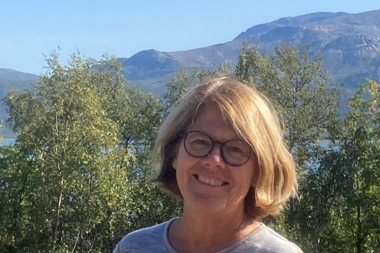 Kari Loe Hjelle smilende i forgrunnen på feltarbeid