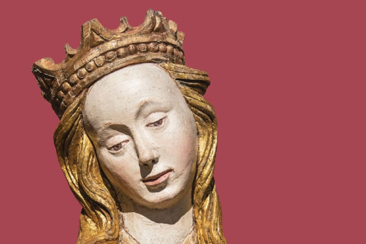Treskulptur av kvinne med gyldent hår og gullkrone